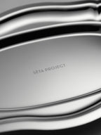 Oval stainless steel tray with smooth, curved edges and polished finish, engraved "SETA PROJECT" at the center.