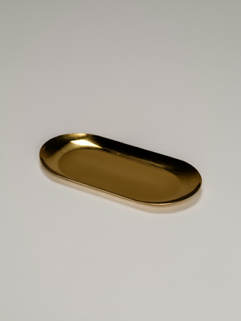 Sleek elongated gold metal tray with rounded edges and a smooth reflective surface.